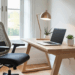 Home office funcional em um cômodo da casa com mesa, cadeira ergonômica e decoração simples.