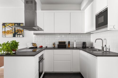 Cozinha organizada com potes de vidro etiquetados, bancadas limpas e utensílios pendurados em organizadores.